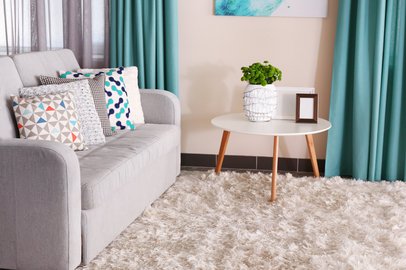 beautiful gray sofa next to green curtains